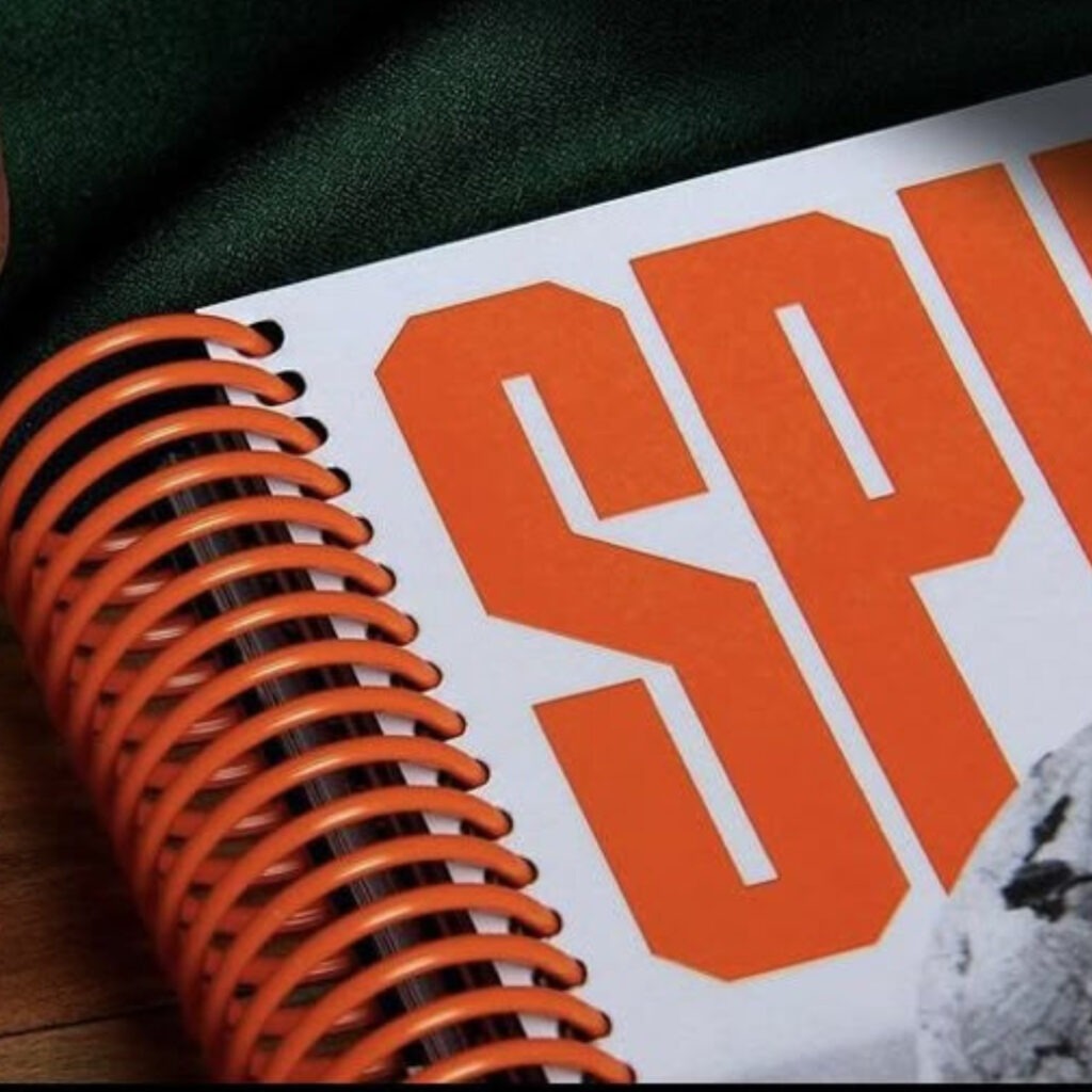 Spiral bound booklet with orange spiral and orange text 